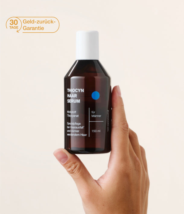Eine rechte Hand hält das Thiocyn Haarserum Männer senkrecht nach oben. Ein Badge, das die 30-Tage-Geld-zurück-Garantie ausweist, ist links daneben platziert. Eine rechte Hand hält das Thiocyn Haarserum Männer senkrecht nach oben. Ein Badge, das die 30-Tage-Geld-zurück-Garantie ausweist, ist links daneben platziert.