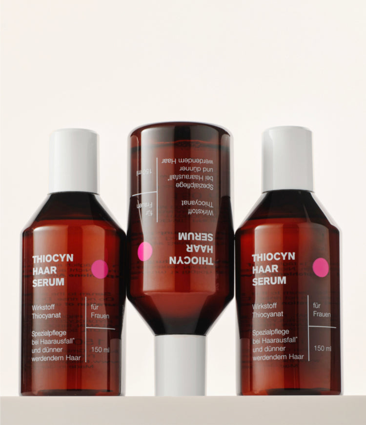 Drei Einzelflaschen des Thiocyn Haarserums Frauen. Die erste und dritte Flasche stehen auf dem Flaschenboden, während die mittlere Flasche auf dem Kopf steht. Drei Einzelflaschen des Thiocyn Haarserums Frauen. Die erste und dritte Flasche stehen auf dem Flaschenboden, während die mittlere Flasche auf dem Kopf steht.