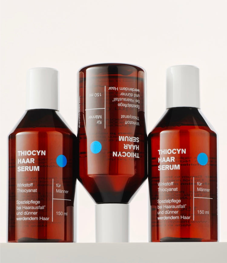 Drei Einzelflaschen des Thiocyn Haarserums Männer. Die erste und dritte Flasche stehen auf dem Flaschenboden, während die mittlere Flasche auf dem Kopf steht. Drei Einzelflaschen des Thiocyn Haarserums Männer. Die erste und dritte Flasche stehen auf dem Flaschenboden, während die mittlere Flasche auf dem Kopf steht.